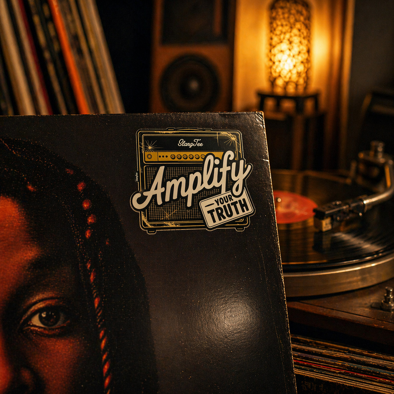 Vinyl record with 'Amplify Your Truth' sticker in a record player room