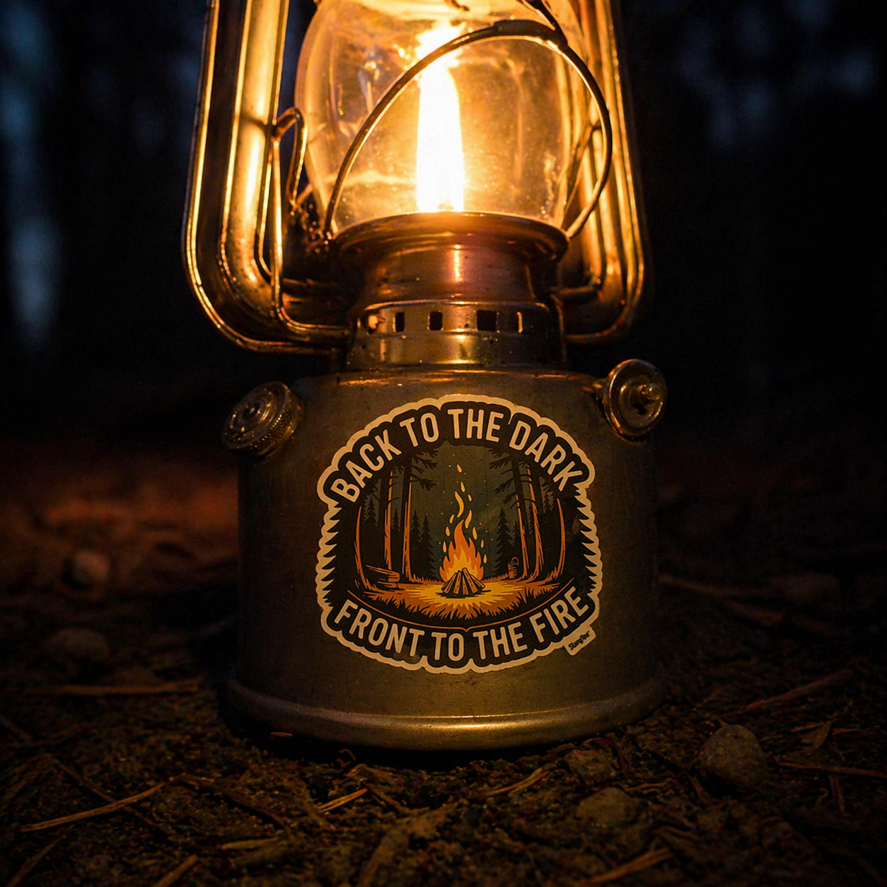 Vintage-style lantern with a sticker 'Back to the Dark, Front to the Fire' in a dark setting.
