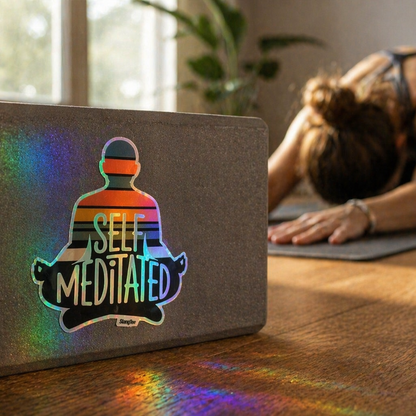 Yoga block with 'Self Meditated' logo on a mat, woman in background