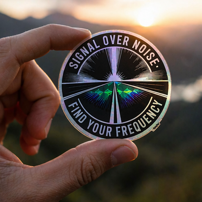 Hand holding a 'Signal Over Noise: Find Your Frequency' sticker with a sunset background.